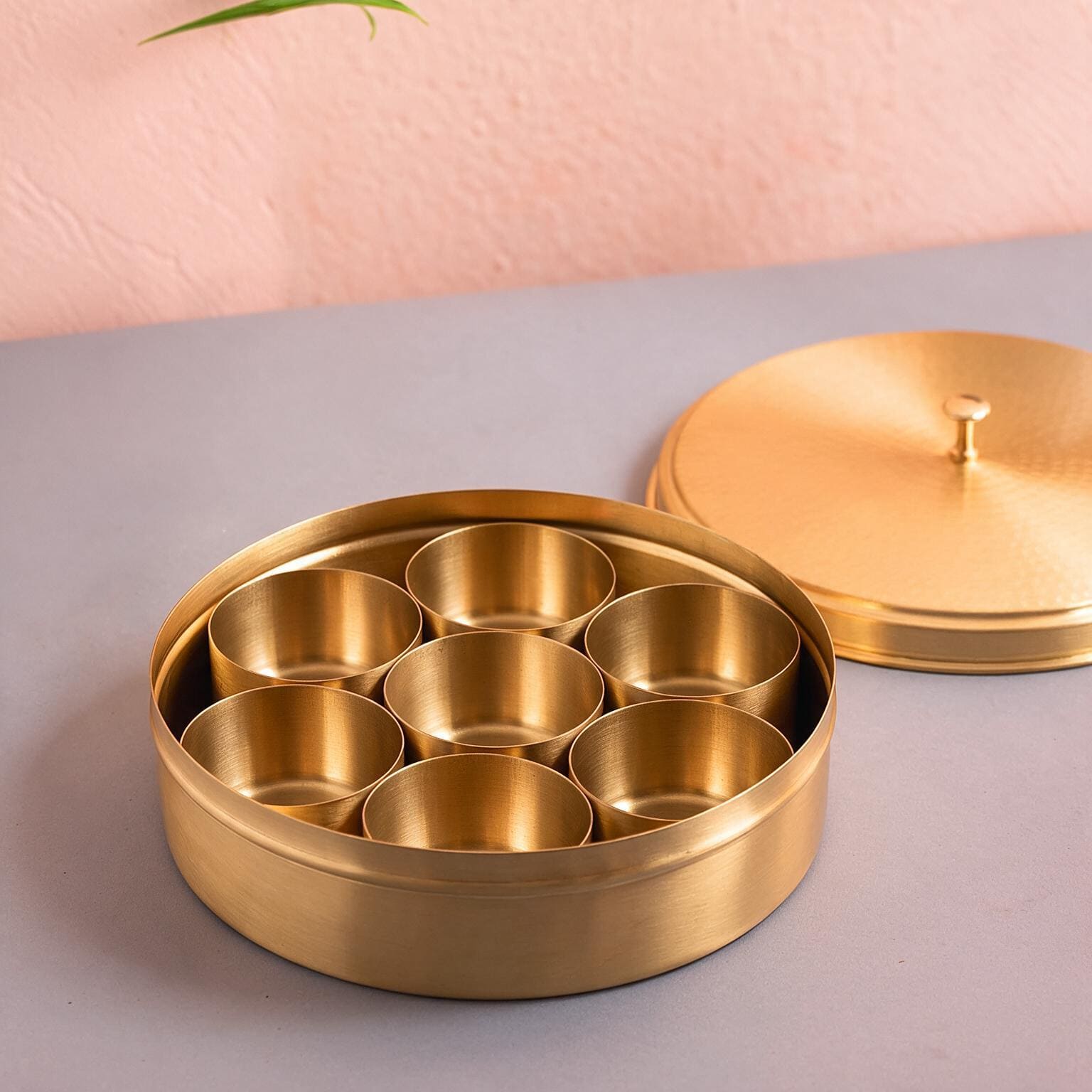 Open brass masala dabba with seven empty compartments