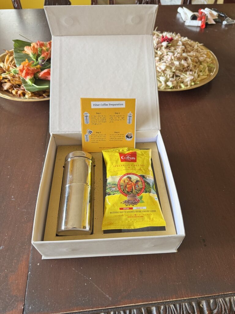 The open box: a stainless steel coffee filter, South Indian filter coffee and a preparation card