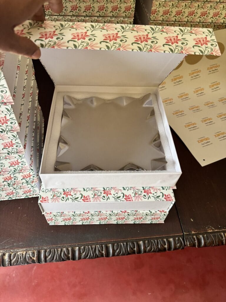 Return gift box opened to show the padded insert and silver piece inside